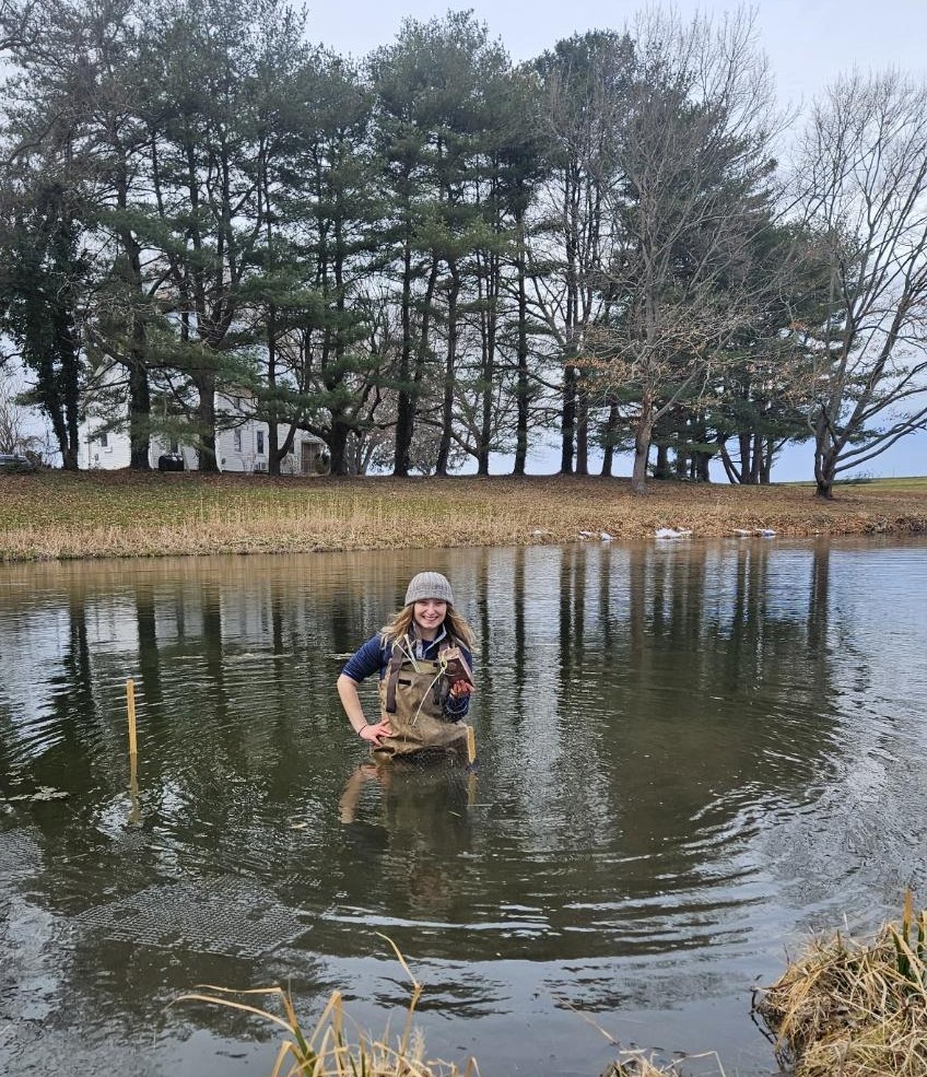 Goodman  standing in research site pond