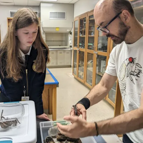 Todd Waters with an insect in the Insect Zoo