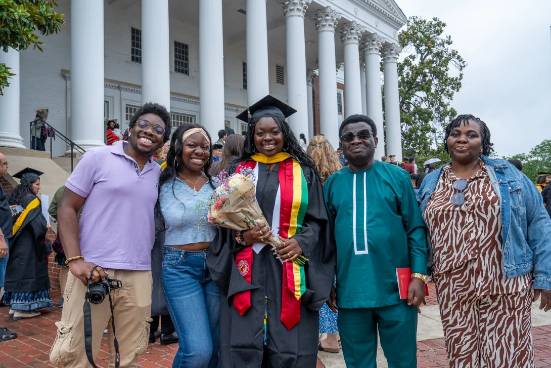 Graduate posing with family outside the Reckord Armory